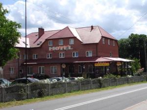 a large red building with a motel on the side of the road at Motel u Olka Boczów in Boczów