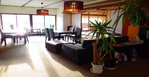 un soggiorno con divano, tavolo e sedie di Oyado Matsubaya / Vacation STAY 8065 a Obinata