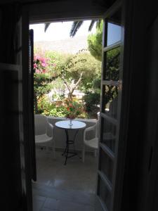 una puerta que conduce a un patio con una mesa y flores en Eden Ios Rooms, en Mylopotas