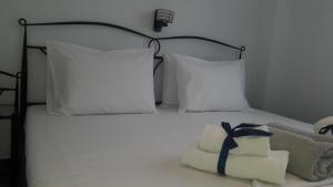 uma cama branca com almofadas brancas e uma toalha em Friends 2 Apartment em Perea