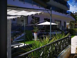 a patio with an umbrella and some plants at Hotel My Fair in Lido di Jesolo
