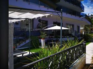 eine Terrasse mit Sonnenschirm und einigen Pflanzen in der Unterkunft Hotel My Fair in Lido di Jesolo