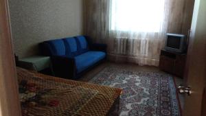 ジヴェエヴォにあるДвухэтажный коттеджの青い椅子とテレビが備わる客室です。