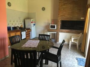 cocina con mesa, sillas y nevera en Departamento Carlos paz en Villa Carlos Paz