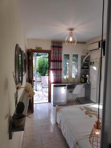 a bedroom with a bed and a kitchen with a table at Villa Romantza in Fiskardo