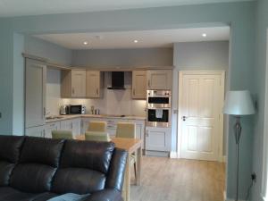 a living room with a couch and a kitchen at Necarne Manor Apartment in Irvinestown