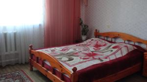 ジヴェエヴォにあるДвухэтажный коттеджのベッドルーム1室(花の毛布付きの木製ベッド1台付)