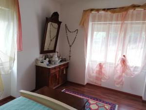 a bedroom with a mirror and a dresser and windows at Villa Frane 101 in Beli