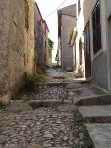 an alley with a stone walkway between two buildings at Villa Frane 101 in Beli