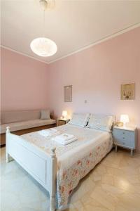 ein Schlafzimmer mit einem weißen Bett und einem Sofa in der Unterkunft Makrygialos sun and sea home in Makry Gialos