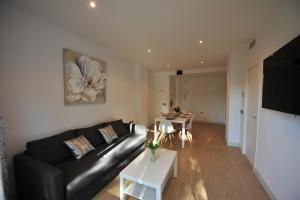 salon z czarną skórzaną kanapą i stołem w obiekcie Diseño Terraza dos baños Piscina w mieście Jerez de la Frontera