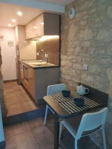 uma cozinha com mesa e cadeiras e uma cozinha com lavatório em Les Buis em Castelnaud La Chapelle