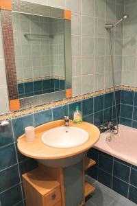 a bathroom with a sink and a mirror and a tub at Apartamento RH in Nazaré