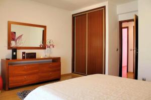 a bedroom with a bed and a dresser with a mirror at Apartamento RH in Nazaré
