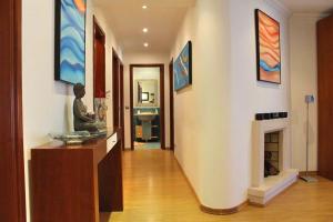 a hallway of a home with a fireplace and paintings at Apartamento RH in Nazaré