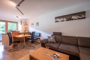 ein Wohnzimmer mit einem Sofa und einem Tisch in der Unterkunft Appartement Unterbering in Söll
