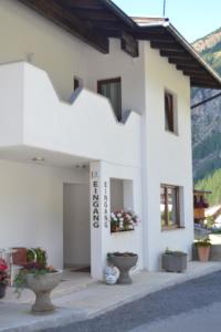 a white building with potted plants in front of it at Gästehaus Judith in Sölden