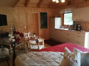 ein Schlafzimmer mit einem Bett und einem Tisch sowie eine Küche in der Unterkunft Ferienhaus Barbara in Ebenthal