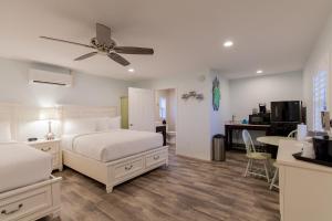 una camera da letto con due letti e un ventilatore a soffitto di Lost Inn Paradise a Cocoa Beach