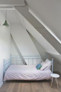 a bedroom with a bed and a table in a attic at Brygga in Bruges