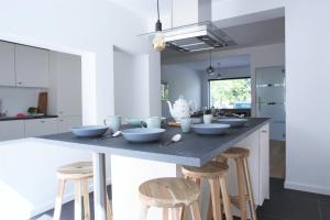 a kitchen with a large island with stools at Brygga in Bruges