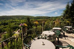 a restaurant with tables and chairs on a balcony with a view at Café und Pension Theodor Fontane in Altenbrak