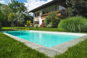 a swimming pool in a yard next to a house at Pension Georgenhof in Cermes