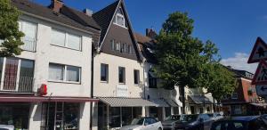 eine Stadtstraße mit vor Gebäuden geparkten Autos in der Unterkunft Lovely City House in Meerbusch