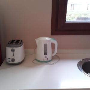 a coffee maker and a toaster sitting on a counter at Departamento Dina Huapi Bariloche in Dina Huapi