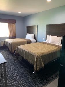 A bed or beds in a room at Scottish Inns and Suites Scarsdale