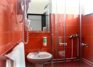 uma casa de banho com um lavatório e um chuveiro em Hotel Cubata na Nazaré