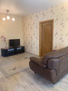 a living room with a couch and a television at Александра Поля проспект Апартаменты in Dnipro
