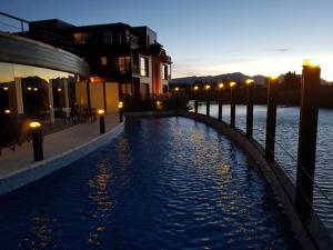a pool of water with lights next to a river at Departamento Dina Huapi Bariloche in Dina Huapi