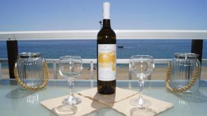 a bottle of wine sitting on a table with two wine glasses at House Kohili in Nea Vrasna