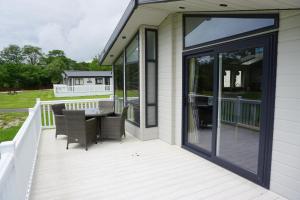 a screened porch with a table and chairs at Lodge 77 in St Austell