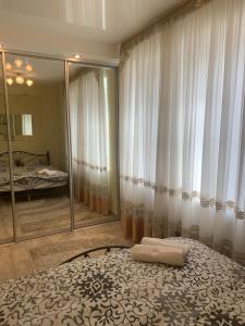 een slaapkamer met een bed en een grote spiegel bij Александра Поля проспект Апартаменты in Dnipro