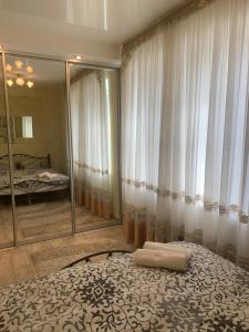 a bedroom with a bed and a large mirror at Александра Поля проспект Апартаменты in Dnipro