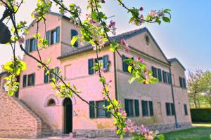 an old pink building with flowers in front of it at I Ciliegi in Osimo
