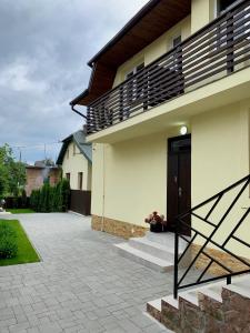 a house with a balcony and a staircase next to it at Водограй, курортна вілла in Morshin