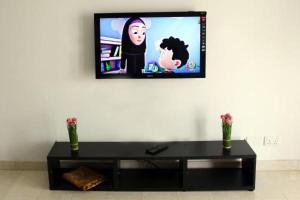 a living room with a television on a wall at NOOR PLAZA BEACH FURNISHED FLATS in Salalah