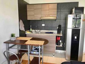 a small kitchen with a table and a refrigerator at COSY STUDIO APARTMENT GREAT LOCATION (203) in Bogotá