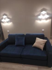 Sofá azul en una sala de estar con 2 luces en MD Apartments, en Jūrmala