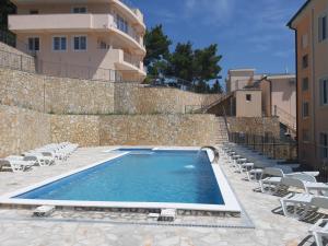 une piscine avec des chaises et un bâtiment en arrière-plan dans l'établissement Villa Roan, à Bar
