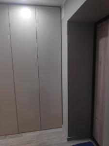 un armario con armarios blancos y una alfombra azul en MD Apartments, en Jūrmala