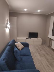 sala de estar con sofá azul y TV en MD Apartments, en Jūrmala