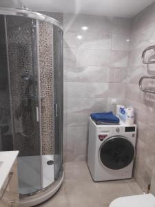 y baño con ducha y lavadora. en MD Apartments, en Jūrmala