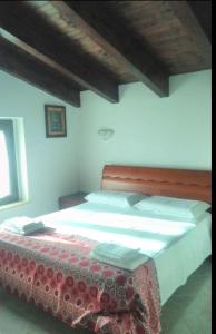 a bedroom with a large bed with a red headboard at La casetta in Ortona