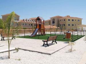 un parque con parque infantil con bancos y tobogán en Seana House in a luxury resort in Protaras area close to the Sea, en Paralimni