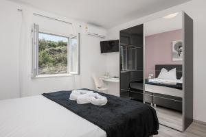 Habitación blanca con cama y ventana en Apartments Lidija en Cavtat