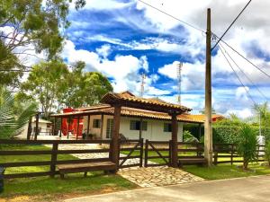 a small house with a wooden fence and a bench at Casa de Temporada em Capitólio (Paz e Tranquilidade) in Capitólio